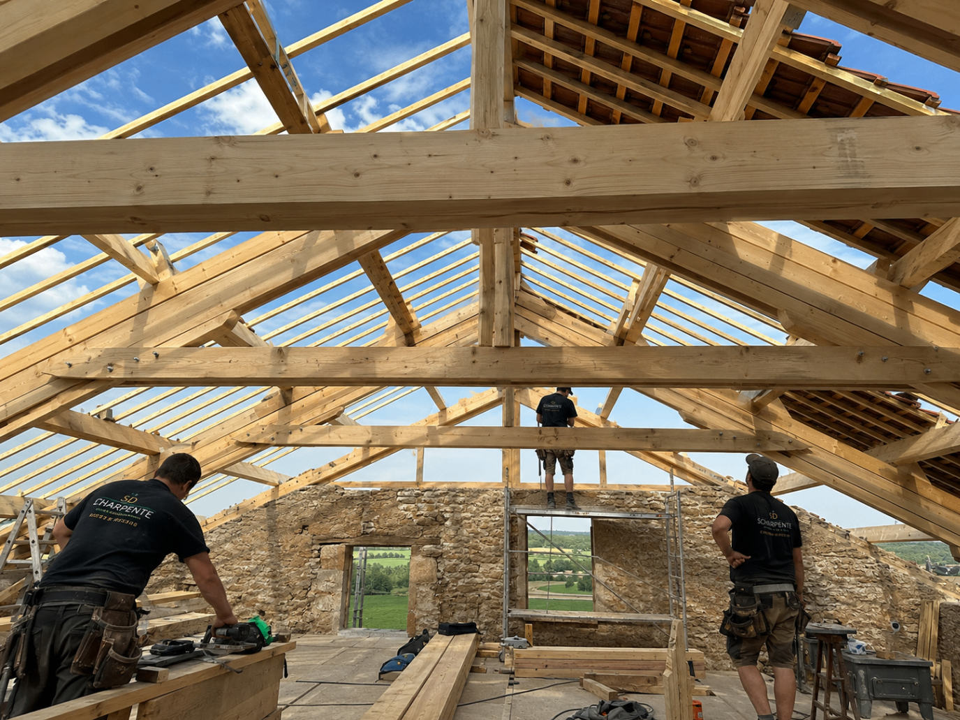 Grande charpente bois neuve installée dans une bâtisse en pierre